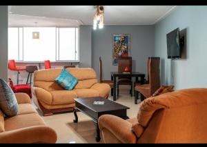 a living room with couches and chairs and a table at Mai Paradise in Kingsburgh