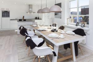 a kitchen and dining room with a table and chairs at Bootsmanns Hüs in List