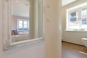 un bagno con uno specchio sul muro e un water di Ausblick - Momme a List Altre 59 foto