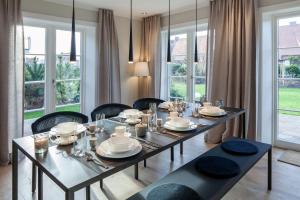 uma sala de jantar com mesa, cadeiras e janelas em Auszeit em List