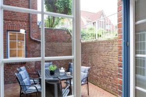 a patio with a table and chairs and a brick wall at Cap Blanco in List