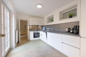 a kitchen with white cabinets and a large window at Cap Blanco in List