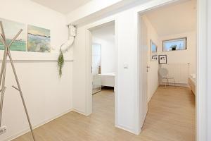 a hallway with white walls and a doorway to a room at Cap Blanco in List