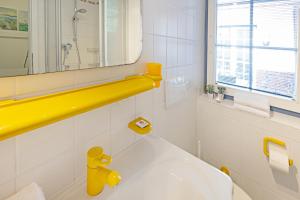 a bathroom with a white tub and a yellow sink at Cap Blanco in List +32 photos