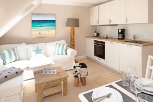 a living room with a white couch and a kitchen at Sylter Perle in List +13 photos