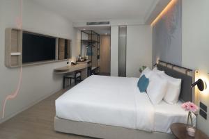 Postel nebo postele na pokoji v ubytování JonoX Phuket Karon Hotel