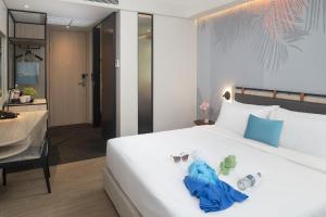 Postel nebo postele na pokoji v ubytování JonoX Phuket Karon Hotel