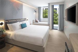 Postel nebo postele na pokoji v ubytování JonoX Phuket Karon Hotel