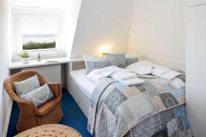 a bedroom with a bed and a chair and a window at Offshore in List