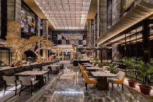 um restaurante com mesas, cadeiras e plantas em Hotel Okura Manila - Staycation Approved em Manila