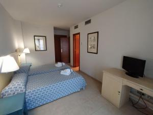 pokój hotelowy z dwoma łóżkami i telewizorem w obiekcie DOS DORMITORIOS CON TRES TERRAZAS EN CUARTA PLANTa w mieście Isla Canela