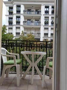 un tavolo e sedie su un balcone con un edificio di Evergreen a Belgrado