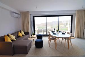 ein Wohnzimmer mit einem Sofa und einem Tisch in der Unterkunft Balcon del Mar 43 apto 123 in Málaga