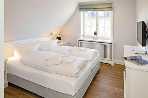 a white bed in a room with a window at Sunset in List