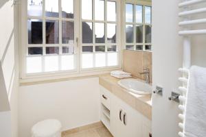 a bathroom with a sink and two windows at Sunset in List +33 photos