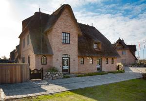 a large brick house with a thatched roof at Sunset in List