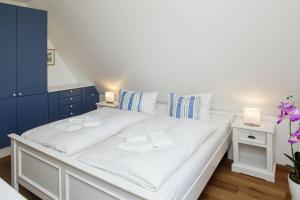 uma cama branca num quarto com duas mesas de cabeceira em Senenskiin em List