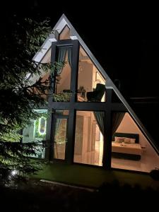 a large window of a house with a couch in it at Pine Hill Poiana Marului in Poiana Mărului