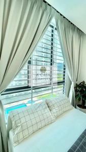 un letto in una camera con una grande finestra di A' Casa Homestay Ipoh Perak a Ipoh