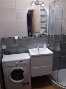 een badkamer met een wasmachine en een wastafel bij Apartament Magda in Kołobrzeg