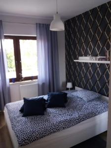 een slaapkamer met een groot bed met blauwe kussens bij Apartament Magda in Kołobrzeg