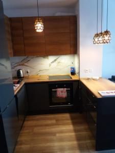 een keuken met houten werkbladen en een fornuis met oven bij Apartament Magda in Kołobrzeg