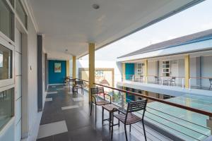 a balcony with chairs and a swimming pool at RedDoorz Plus @ Point Phila Cihampelas in Bandung