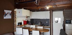 a small kitchen with a table and white cabinets at Coup de coeur - Centre station, Proche pistes de ski in Les Deux Alpes