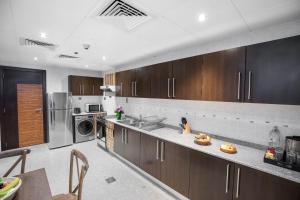 a large kitchen with wooden cabinets and stainless steel appliances at City Premiere Hotel Apartments - Dubai in Dubai