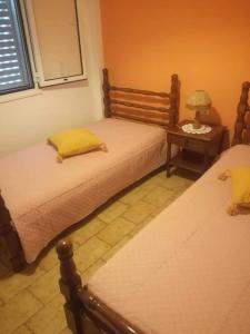 a bedroom with two beds and a table with a lamp at panorama view apartment in Sitia