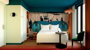 a bedroom with a white bed and a blue headboard at Ibis Styles Paris Batignolles in Paris