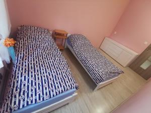 two beds in a small room with at Przystań Familijna in Santoczno