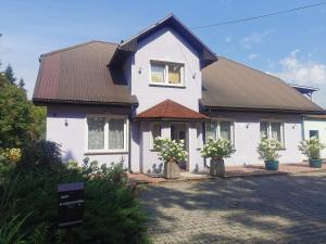 a white house with a brown roof at Przystań Familijna in Santoczno