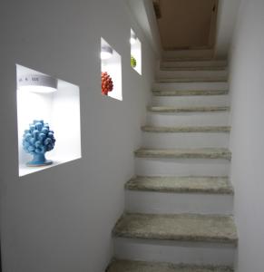 ジョヴィナッツォにあるLa Terrazza sul mare - Dimora di Charmeの青花瓶が窓に座る階段