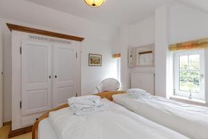 キュールングスボルンにあるHaus-Rolandseck-Wohnung-11-416の白い壁の客室で、ベッド2台、窓が備わります。