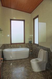 y baño grande con bañera y aseo. en Thỏ Non Garden Villa Bảo Lộc, en Bao Loc