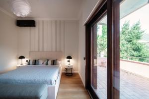 コモにあるJOIVY Villa Sofiaのベッドとガラスの引き戸のある寝室