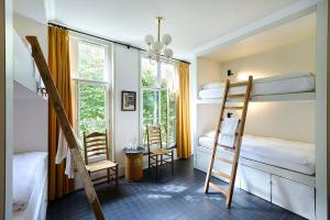 Zimmer mit 2 Etagenbetten sowie einem Tisch und Stühlen in der Unterkunft Hello I'm Local - Boutique Hostel in Haarlem