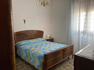 Un dormitorio con una cama con un edredón azul y amarillo. en Da nonna Anna, en Torre Canne