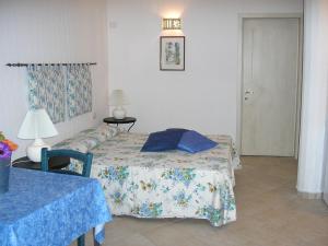 a bedroom with a bed and a table and a lamp at Appartamenti Il Giardino in Porto Rotondo