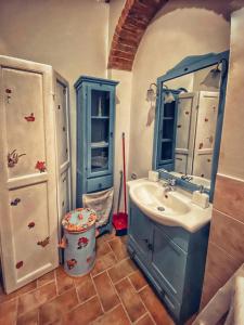 a bathroom with a blue sink and a mirror at La Casina MAG in Pienza
