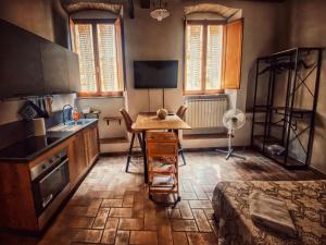 uma pequena cozinha com uma mesa e um lavatório em La Casina MAG em Pienza