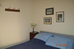 una camera da letto con un letto e alcuni quadri sul muro di La casa di Agata a Guardistallo