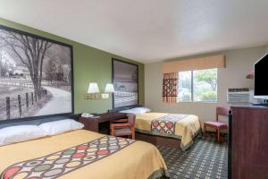 a hotel room with two beds and a flat screen tv at Super 8 by Wyndham Youngstown/Austintown in Youngstown