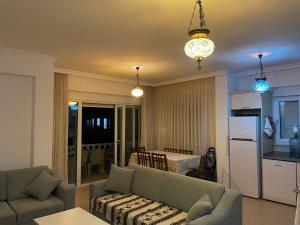 uma sala de estar com um sofá e uma sala de jantar em Fantastic Apt-2 min walk from Belek Cent’r Antalya region, great for golf lovers em Belek