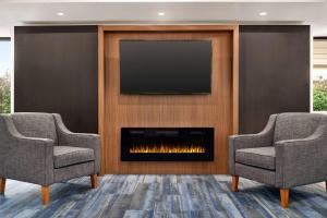 a living room with two chairs and a fireplace at La Quinta Inn by Wyndham Columbus Dublin in Dublin