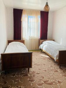 um quarto de hotel com duas camas e uma janela em Гостевой дом с панорамными окнами em Guiumri