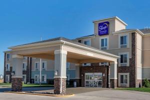 a hotel with a sign on the front of a building at Sleep Inn & Suites Oakley I-70 in Oakley