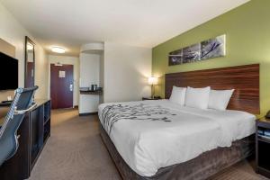 a hotel room with a large bed and a flat screen tv at Sleep Inn & Suites Oakley I-70 in Oakley