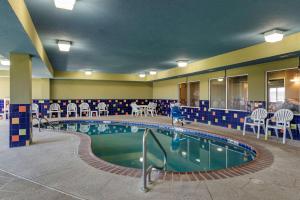 una piscina en una habitación de hotel con sillas y mesas en Sleep Inn & Suites Oakley I-70, en Oakley